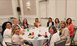 Ardelle Bigos at table at conference
